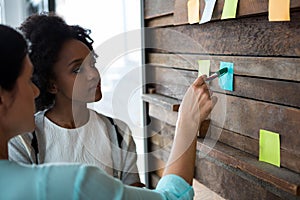 Female graphic designer writing on sticky notes