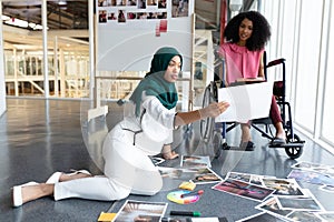 Female graphic designers discussing on photographs in office