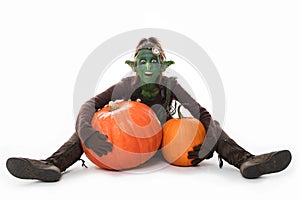 Female green goblin with pumpkins, Halloween