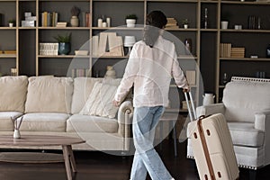 Female guest or new tenant enters living room with suitcase
