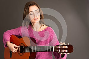 Female guitarist tuning guitar