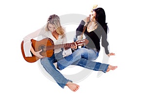 Female guitarists tuning their guitars