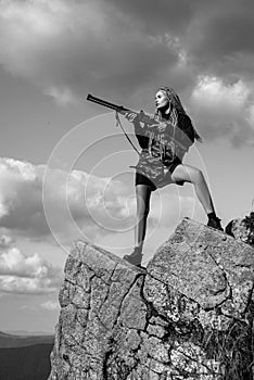 Female with a gun. Woman hunter with a gun. Calibers of hunting rifles. Hunter with a shotgun in a traditional shooting