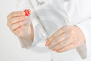 Female gynecologist holding disposable cervical sample swab