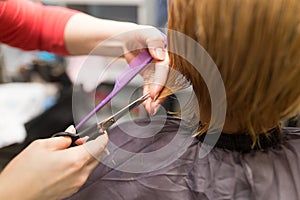 Female hair cutting scissors in beauty salon