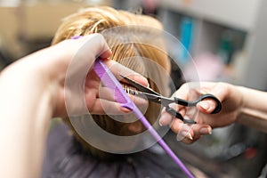 Female hair cutting scissors in beauty salon