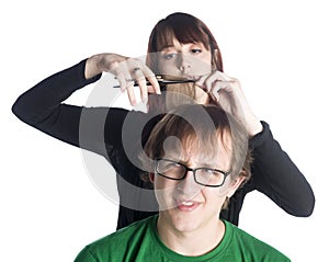 Female hair stylist cutting hair of a worried man