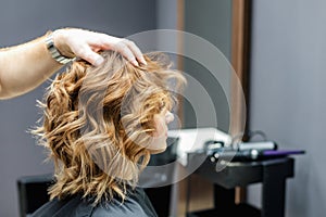 Female hairdresser checking woman`s hairstyle