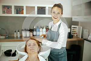female hairdresser in modern beauty studio washing hair