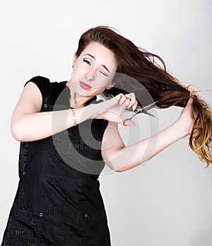 Female Hairdresser trying to cut your own hair with scissors photo