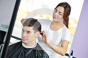 Female hairdresser at work making haircut