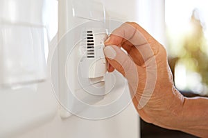 Female hand adjusting temperature with dial on air conditioning