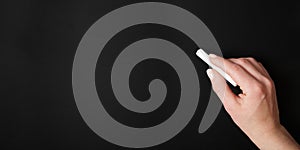 Female hand against blank chalk board background