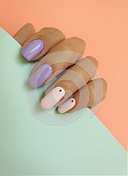 Female hand beautiful stylish summer delicate pastel manicure on a colored background