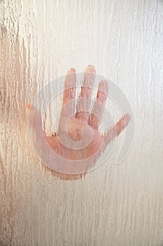 female hand behind frosted glass shower screen