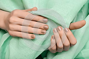 Female hand with beige glitter nail design
