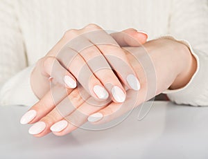 Female hand with beige nail design.