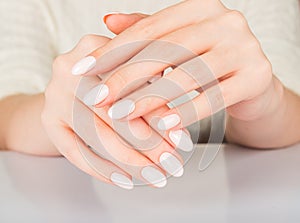 Female hand with beige nail design.