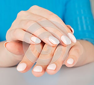 female hand with beige nail design.