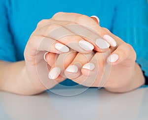 female hand with beige nail design.