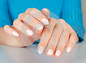 female hand with beige nail design.