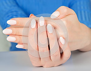 Female hand with beige nail design