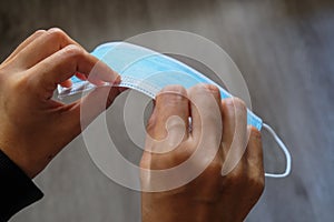 Female hand bending and mould a 3 layer surgery mask