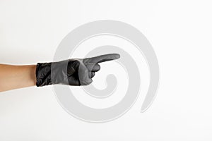 Female hand in black latex gloves pointing from side to free space for text, on white background vertical orientation