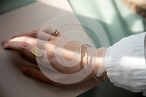 female hand with brass Copper bracelet and gold vintage stylish polished ring