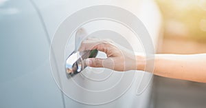 Female hand of a business woman with a pushing open botton of the car door