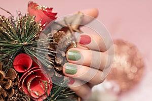 Female hand with Christmas nail design. Glitter Christmas nail polish manicure. Female hand hold Xmas decoration