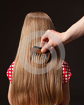 Female hand combing beautiful long hair