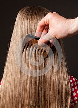 Female hand combing beautiful long hair