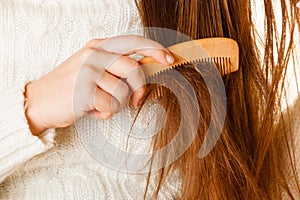 Female hand combing long hair.