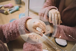 Female hand with cream in front of a mirror