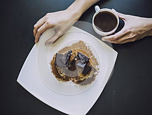 Female hand with a Cup of coffee and a beautiful chocolate cake
