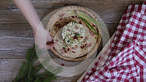 Female hand decorated salad with pomegranate