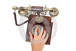 Female hand dialing old-fashioned phone