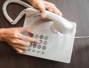 Female hand dialling out on a telephone on keypad photo