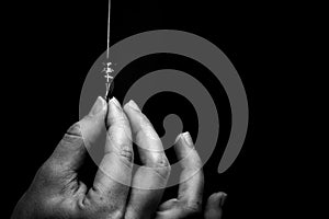 female hand elegantly holding an ink pen with a metal tip close-up on a black background. classic fountain pen isolated