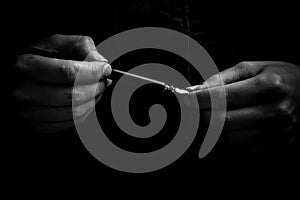 Female hand elegantly holding an ink pen with a metal tip close-up on a black background. classic fountain pen isolated macro