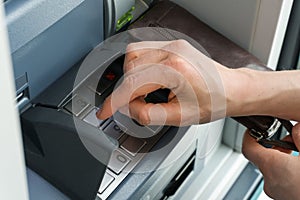 Female hand entering a secure PIN code at a cash point or ATM up close and in detail