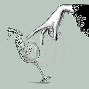 Female hand and a falling glass with splashed wine