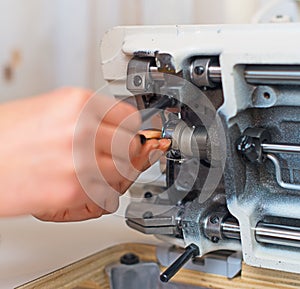 Female hand fixing sewing machine.