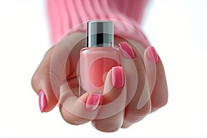 Female hand with French manicure holding pink nail polish bottle