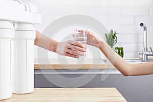 Female Hand giving a glass of clean water. Purified water and healthy life concept.