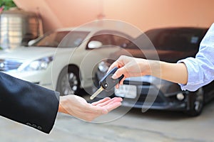 Female hand giving a key for buyer or rental car.