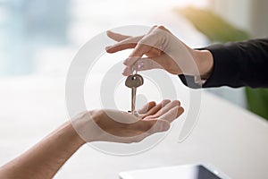 Female hand giving keys to male client, buying renting apartment