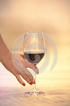 Female hand with a glass of red wine