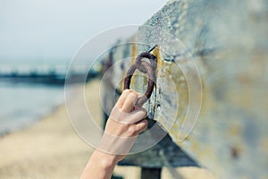 Female hand grabbing rusty chain